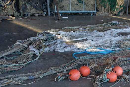 A fishermen's hangar with nets and fishing tools arranged neatly. The covered area provides a workspace for net maintenance, essential for local fishing operations.