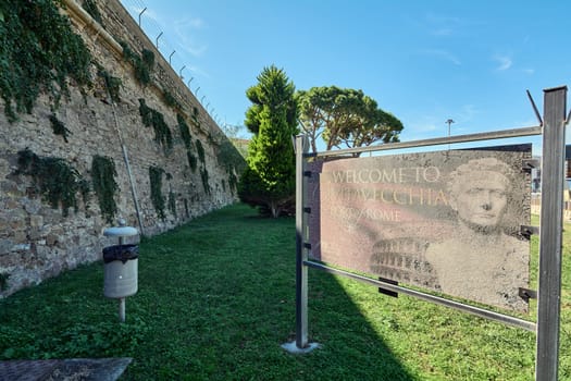 Civitavecchia, Italy - February 02, 2025: A deteriorated welcome board with ancient Roman motifs marks the entrance to this maritime city. Concept: travel, heritage, architecture