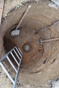 water well top view, with hand construction tool