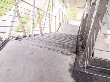 staircase for descending from footbridge. The concrete overpass for crossing the road.
