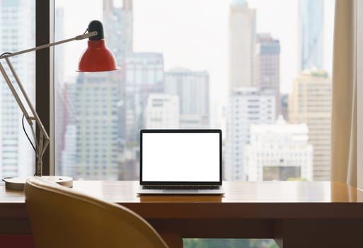 laptop white screen display on workspace see through city blur background