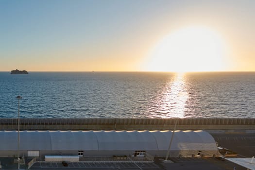Civitavecchia. Italy - February 6, 2025: Sunset at the port of Civitavecchia with a ship on the horizon and the sun reflecting on the sea. Ideal for travel and landscape themes.