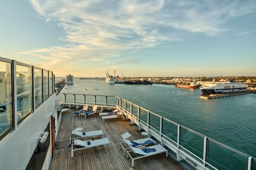 Civitavecchia. Italy - February 6, 2025: Tranquility. Sun loungers neatly arranged on a wooden deck, ready for guests to unwind in a serene, high-end outdoor space.