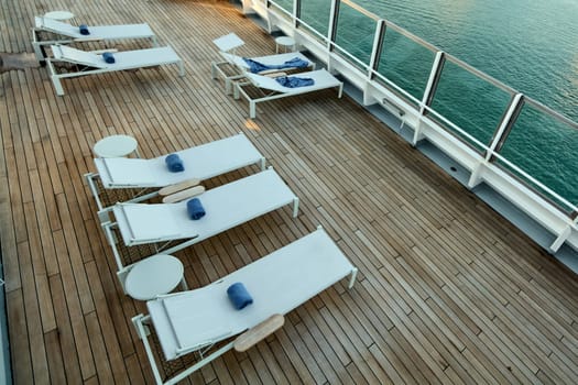 Vacation. Lounge chairs with towels on a wooden floor, symbolizing travel, comfort, and carefree holiday moments in a modern setting.
