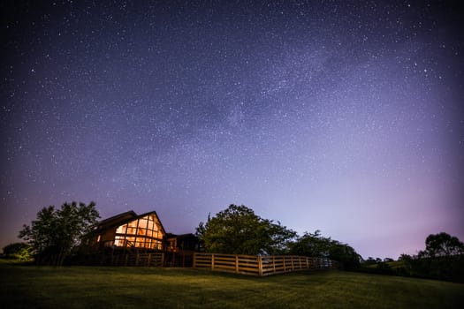 View of night sky and the Milky Way with a house in rural Kentucky in the foreground