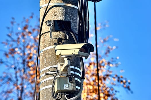 a surveillance camera is hanging on a concrete pillar with an infrared flashlight. High quality photo