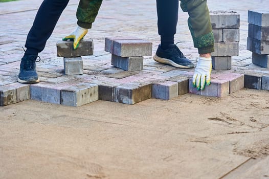 laying paving slabs on the sand with your hands. High quality photo