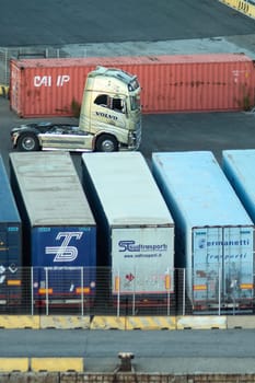 Civitavecchia, Italy - February 7, 2025: Shipping containers in an industrial freight yard. The scene captures cargo logistics and transportation infrastructure. Concept: Global trade and logistics