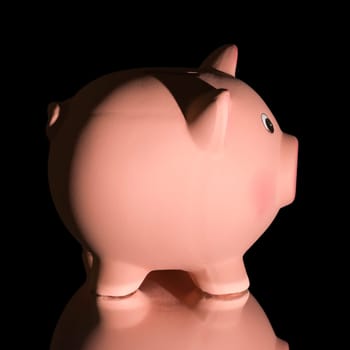 Pink ceramic piggy bank, on black background. Bank savings, economy, financials investments concept