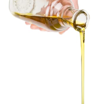 Male hand holding a bottle. Oil pouring from a bottle.