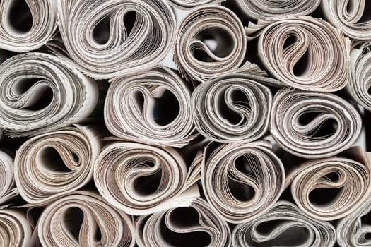 Stack of newspapers rolls, paper texture background.