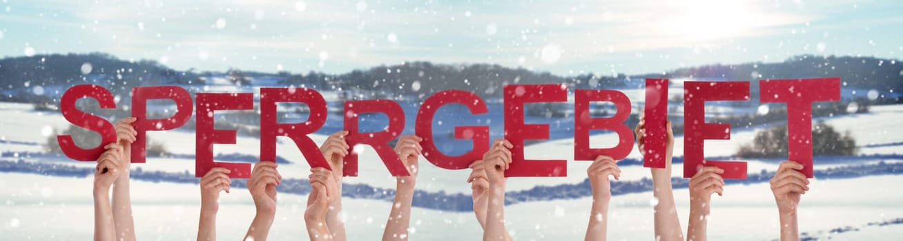 People Hands Holding Colorful German Word Sperrgebiet Means Prohibited Area. Snowy Winter Background With Snowflakes