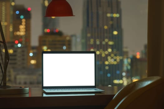 laptop computer on table white display see through city on night background