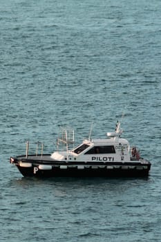 Civitavecchia. Italy - February 7, 2025: Pilot boat in calm waters, used to guide ships into ports. crucial part of maritime trade and navigation. Concept Logistics and port assistance