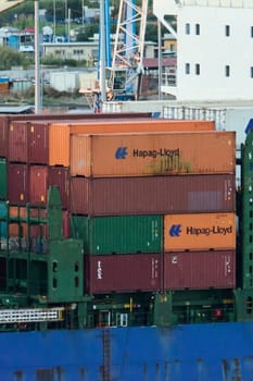 Civitavecchia. Italy - February 07, 2025: Industrial cargo ship carrying stacked containers on the high seas. It represents maritime transport, international trade, freight transport and logistics.