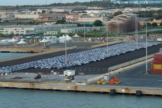 Civitavecchia, Italy - February 7, 2025: Aerial view of cars to be loaded at a port, representing logistics operations and international trade of the automotive industry. Concept: Logistics operations