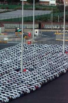 Civitavecchia, Italy - February 7, 2025: Rows of new cars ready to be exported. Represents the automotive industry and global trade. Essential for vehicle distribution networks.