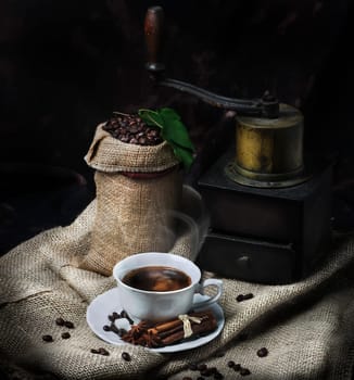 Cup of coffee and vintage coffee mill