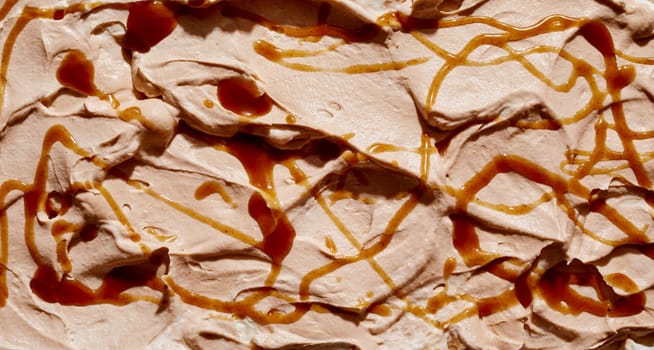 Artisanal Italian caramel ice-cream drizzled with syrup or sauce in a close up on the surface in a full frame background texture for menu advertising