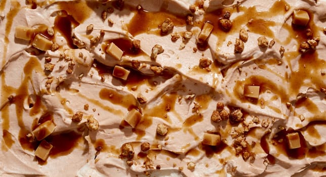 Gourmet caramel ice cream with chopped fresh walnuts and caramel candy in a wide angle panorama background texture for menu advertising