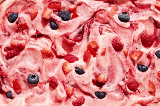 Gourmet speciality creamy mixed berry ice cream with raspberry, strawberry and blueberry fruit chunks in a full frame view for menu or product advertising