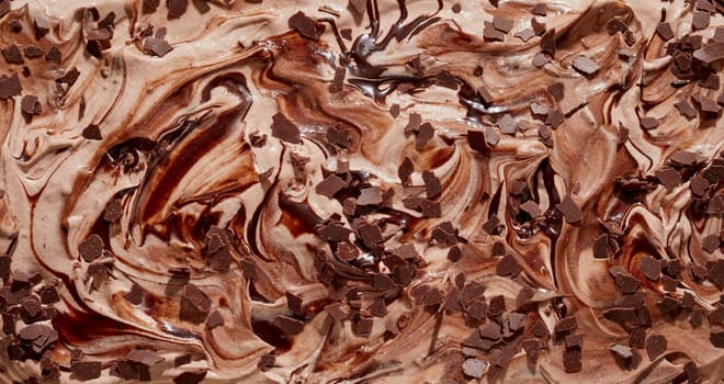 Tasty speciality Italian creamy chocolate ice cream or gelato topped with chocolate flakes in a close up textured background with swirl pattern