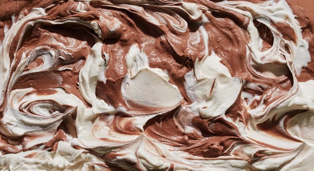 Dual flavour chocolate and vanilla ice-cream or gelato in a close up panorama background texture on the surface of the dessert for menu advertising or food design