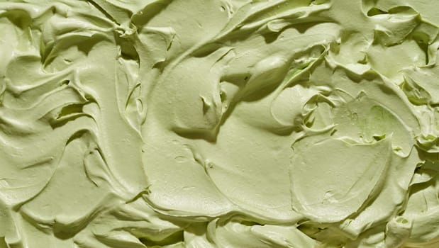 Full frame background texture of green pistachio nut ice-cream with abstract swirled pattern for menu advertising or catering concepts
