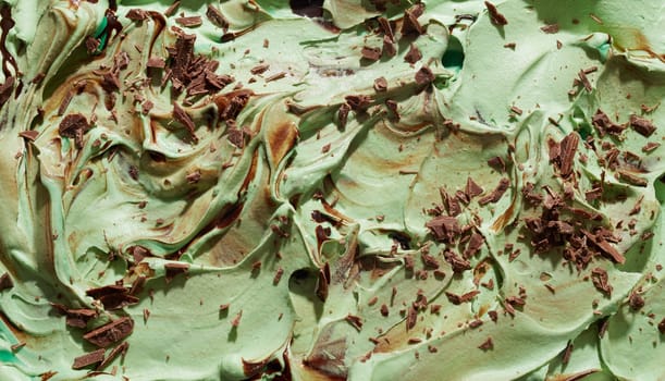 Mint, Japanese green tea or matcha ice cream with chocolate flakes in a textured swirling background texture close up on the surface of the dessert
