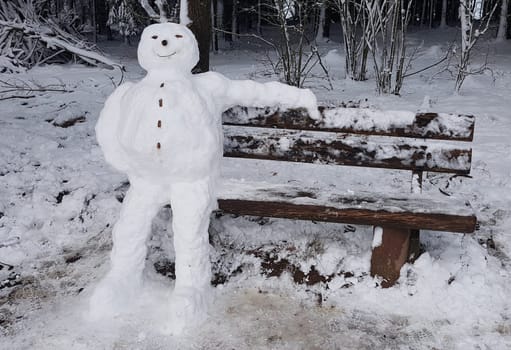 Snowman resting on a bench. Snowman resting on a bench.