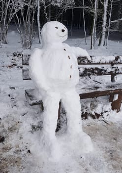 Snowman resting on a bench. Snowman resting on a bench.