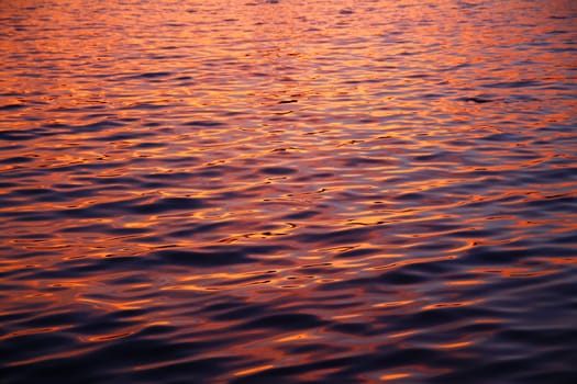 The beauty of the colors of the waves in the water during a summer sunset with a close up shot