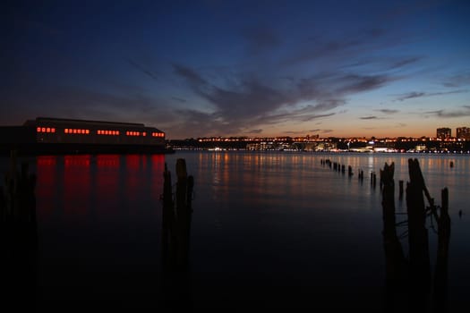 The red lighted pier and the river during the sunset in New York City