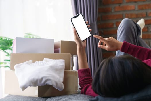 woman lying on the sofa playing on the phone shopping online