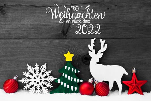 German Calligraphy Frohe Weihnachent Und Ein Glueckliches 2022 Means Merry Christmas And Happy 2022. Red Christmas Decoration Like Ball, Reindeer, Tree And Snowflake. Gray Wooden Background With Snow