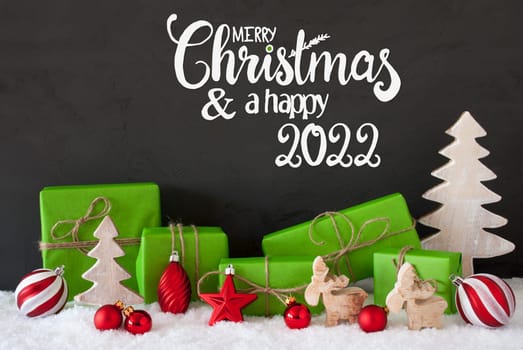 English Calligraphy Merry Christmas And A Happy 2022. Green Christmas Present With Decoration Like Tree, Reindeer And Ball. Black Background With Snow