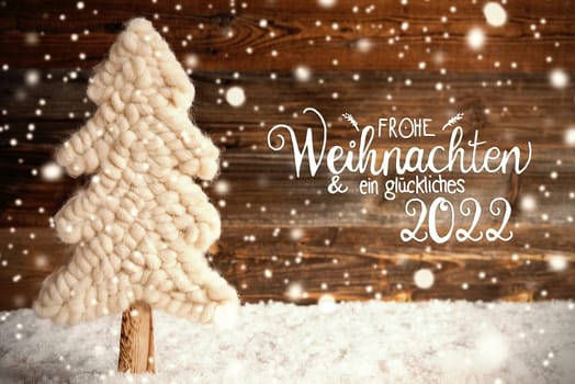 German Calligraphy Frohe Weihnachten Und Ein Glueckliches 2022 Means Merry Christmas And A Happy 2022. White Fabric Christmas Tree With Snow. Brown Rustic Wooden Background With Snowflakes