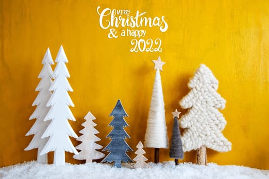 Christmas Trees With English Calligraphy Merry Christmas And A Happy 2022. Yellow Wooden Rustic Background With Snow. Christmas Decoration With Stars.