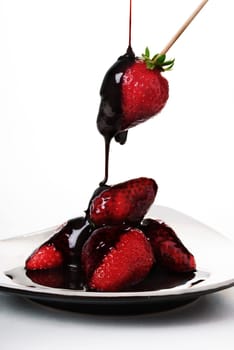 Pouring chocolate over fresh yummy strawberries