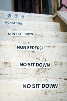 Old do not sit here sign on business entrance