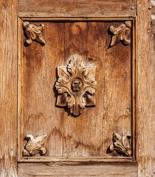 Close up details of old wooden door with carved flowers and wood texture