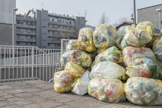 Trash bags on the sidewalk. Transparent bags for differentiated waste collection. Bergamo, ITALY - February 23, 2021.