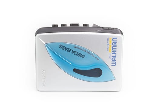 Sony Walkman. Vintage portable audio tape compact cassette player with headphones and cassette. Device on white background. Bergamo, ITALY - March 24, 2021.