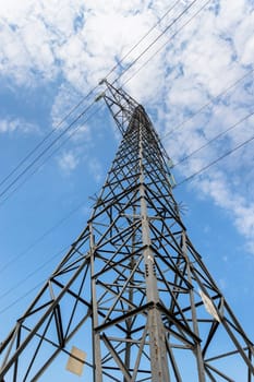 Power transmission tower against the sky. Bottom view. Electricity for transmission of power through electrical networks. Electrical high voltage.