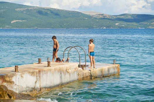 Children playing at a bathing place on the Adriatic Sea near the town of Krk in Croatia