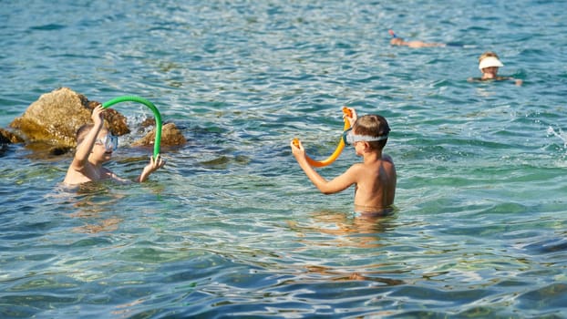 bathing children with diving goggles and snorkel in Adriatic Sea near town Krk in Croatia