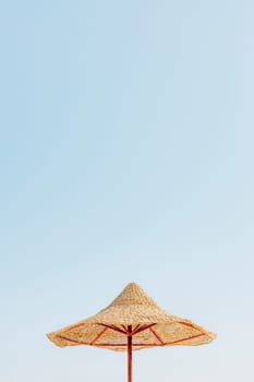 Looking up at wooden straw umbrella or thatched hut from below against beautiful cloudy blue sky view on tropical Egypt beach. Summer or winter holiday concept. Egyptian resort. High quality photo
