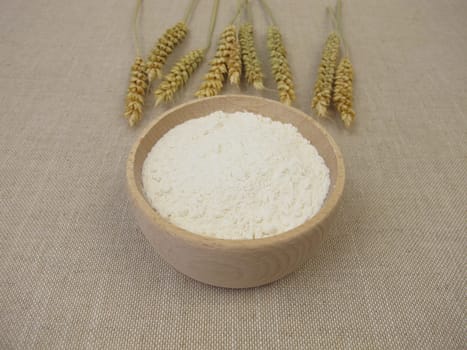 Fine wheat flour in a wooden bowl for the production of baked goods and pasta