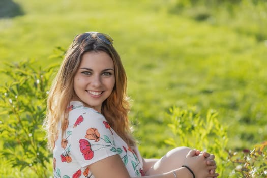 Smiling atractive beautiful  young woman is posing outdoors. Horizontally.