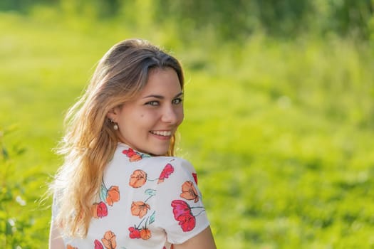Atractive beautiful  young woman is smiling over her shoulder at the camera.  Horizontally.